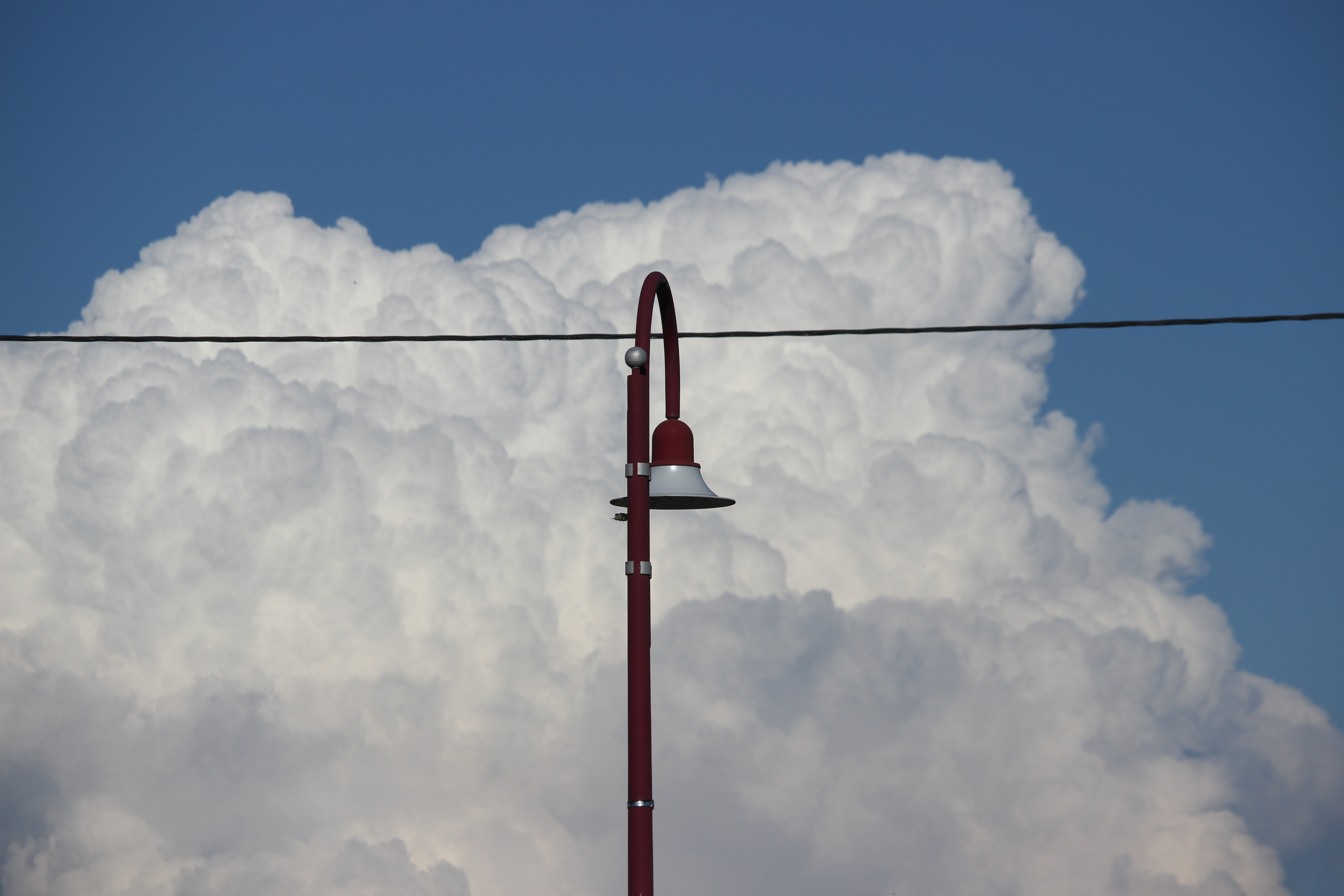 Réverbère rouge devant un nuage orageux